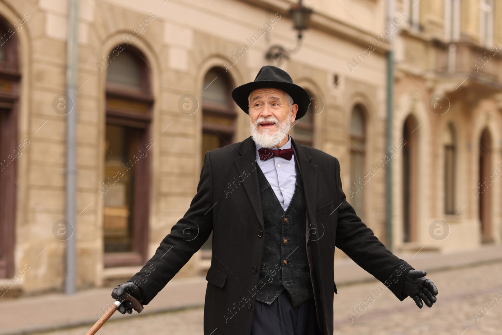 Photo of Elegant senior man with walking cane on city street