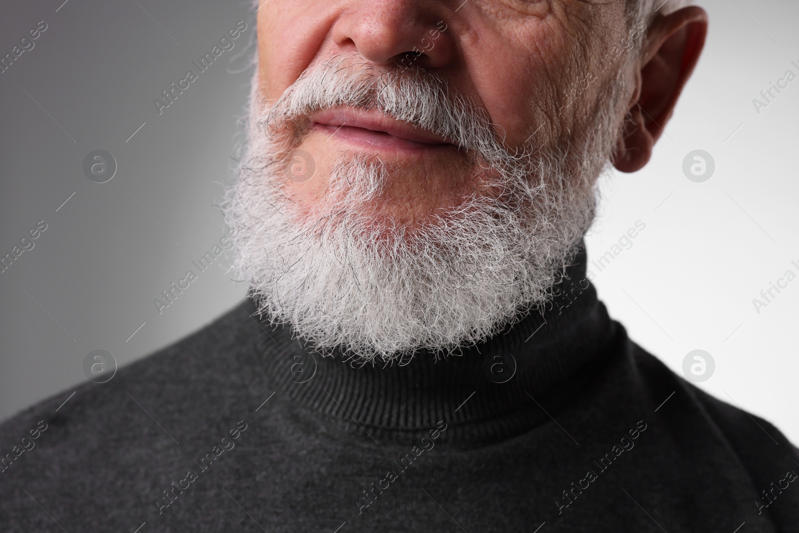 Photo of Senior man with gray beard on light grey background, closeup