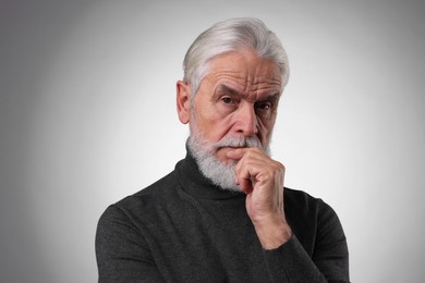 Photo of Portrait of confident senior man with silver beard on light grey background