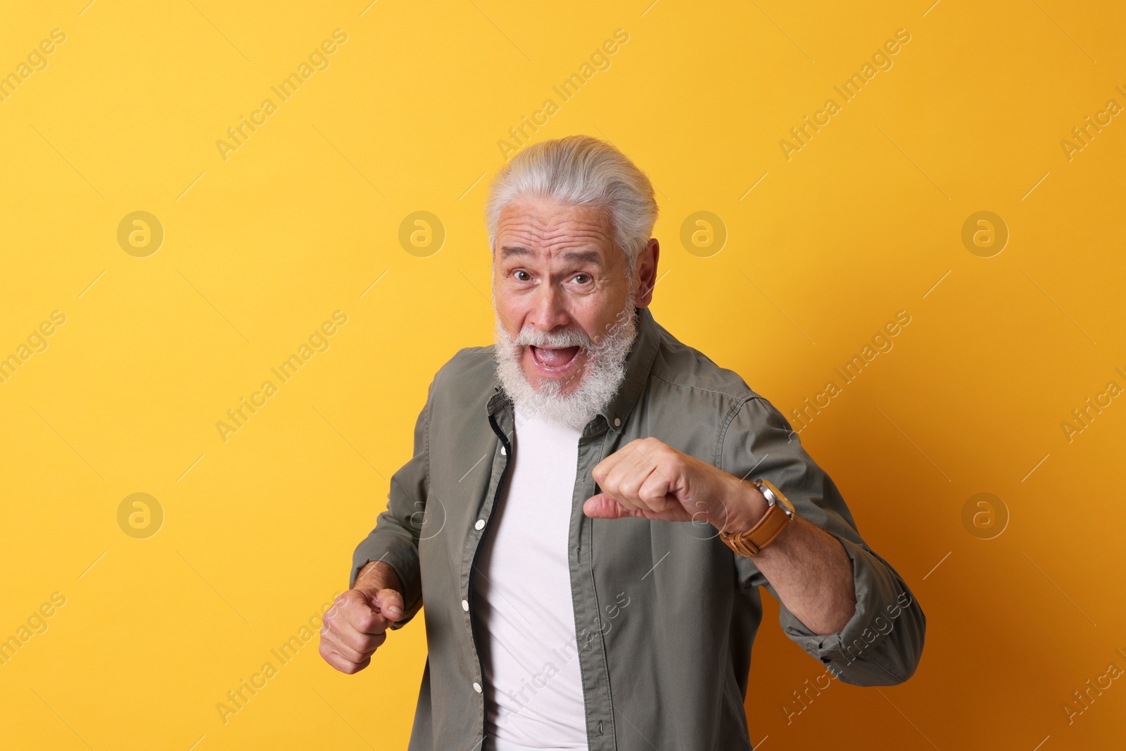 Photo of Portrait of emotional senior man on orange background