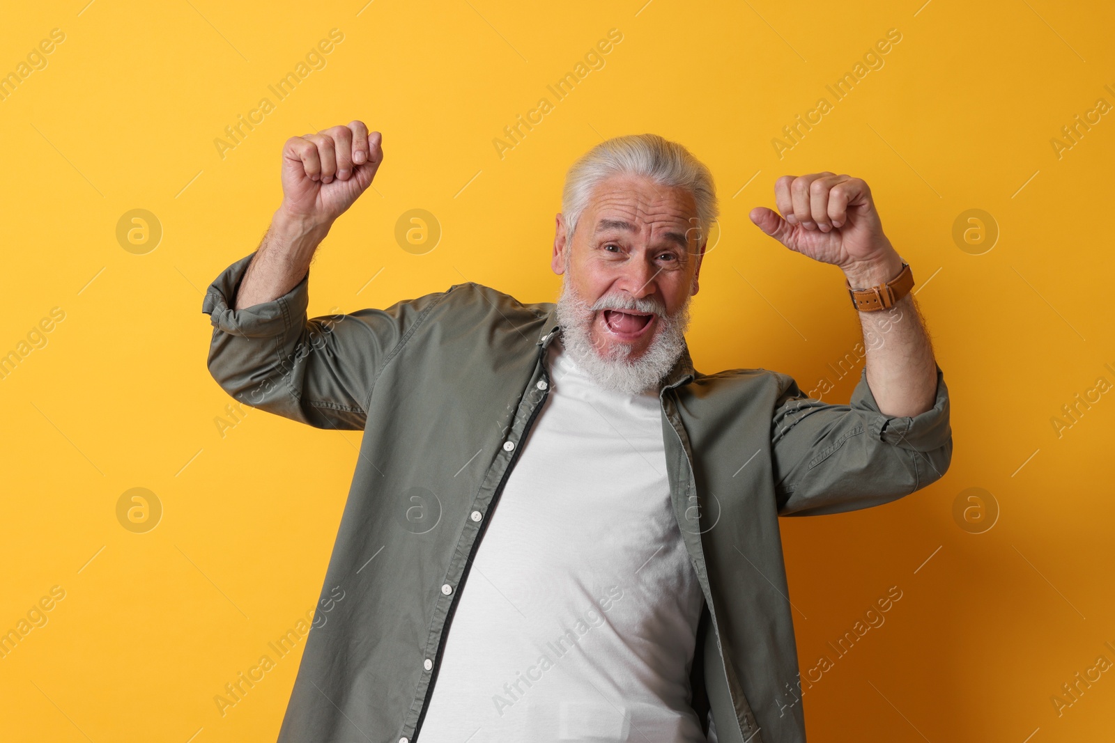 Photo of Portrait of emotional senior man on orange background