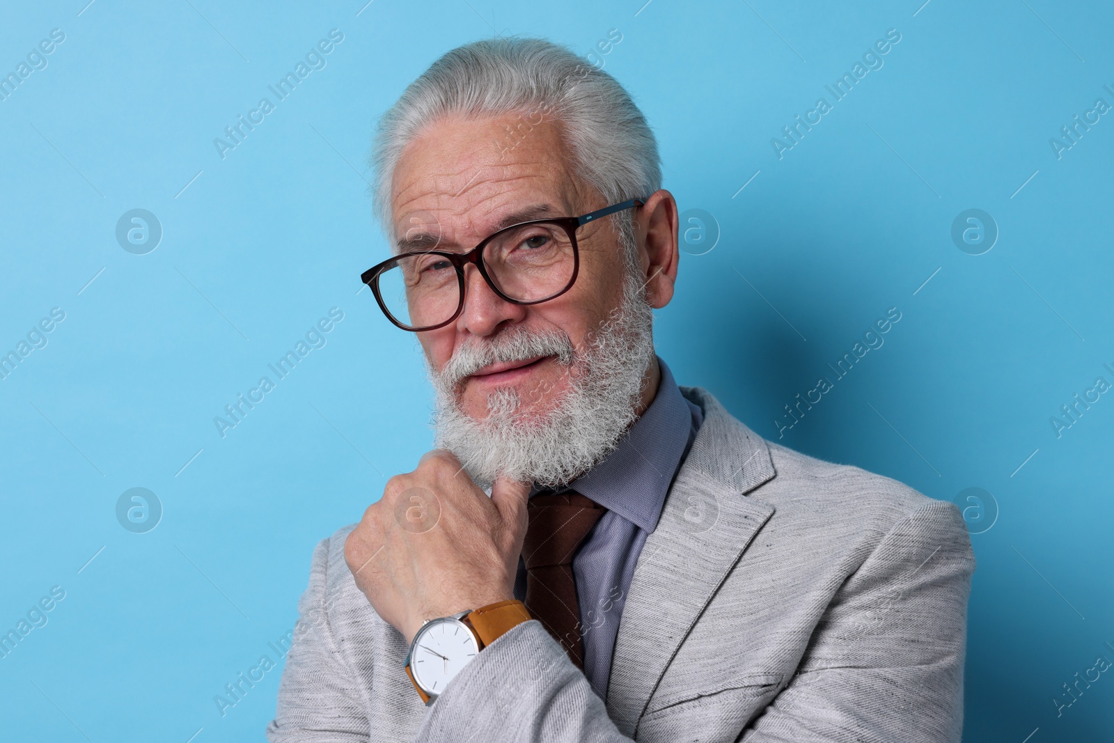 Photo of Portrait of senior man with gray beard on light blue background