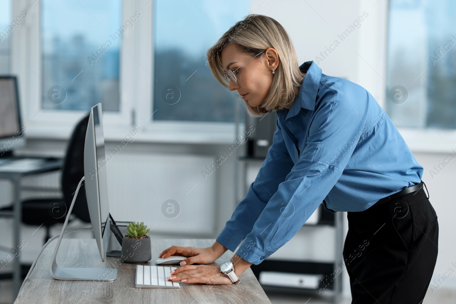 Photo of Technician making digital engineering drawing on computer at desk in office