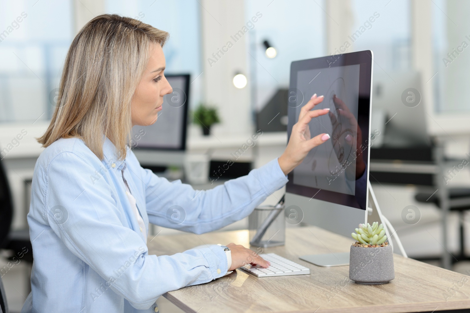 Photo of Technician making digital engineering drawing on computer at desk in office