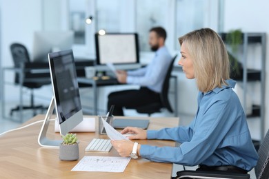 Photo of Technician making digital engineering drawing on computer at desk in office