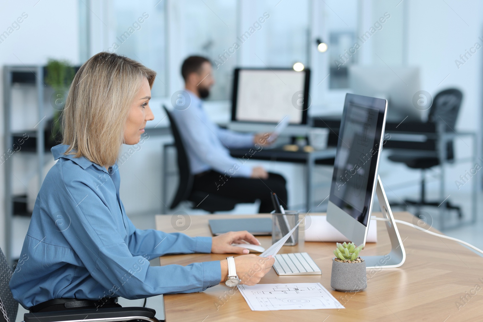 Photo of Technician making digital engineering drawing on computer at desk in office