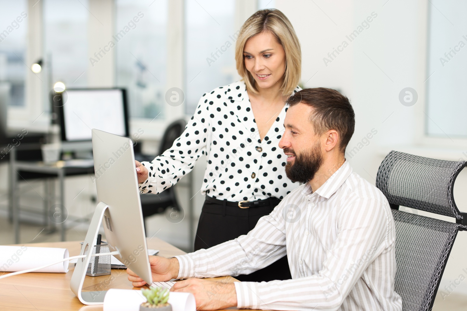 Photo of Technicians making digital engineering drawing on computer at desk in office