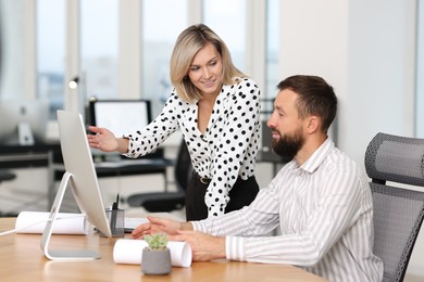 Photo of Technicians making digital engineering drawing on computer at desk in office