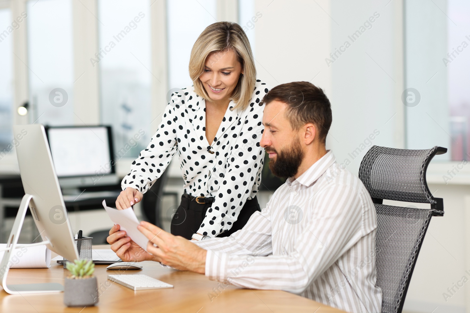 Photo of Technicians making digital engineering drawing on computer at desk in office