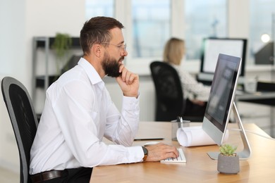 Photo of Technician making digital engineering drawing on computer at desk in office