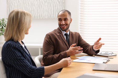 Photo of Coworkers working together at table in office