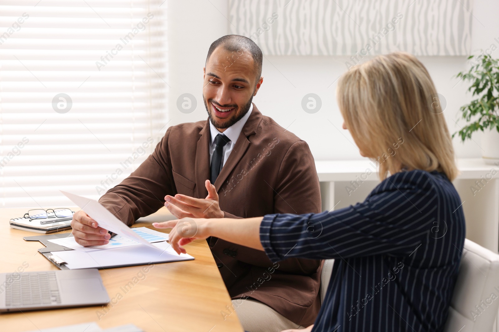 Photo of Coworkers working together at table in office