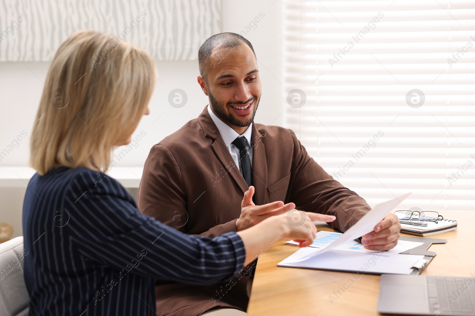 Photo of Coworkers working together at table in office