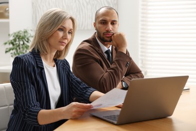 Photo of Coworkers with laptop working together in office