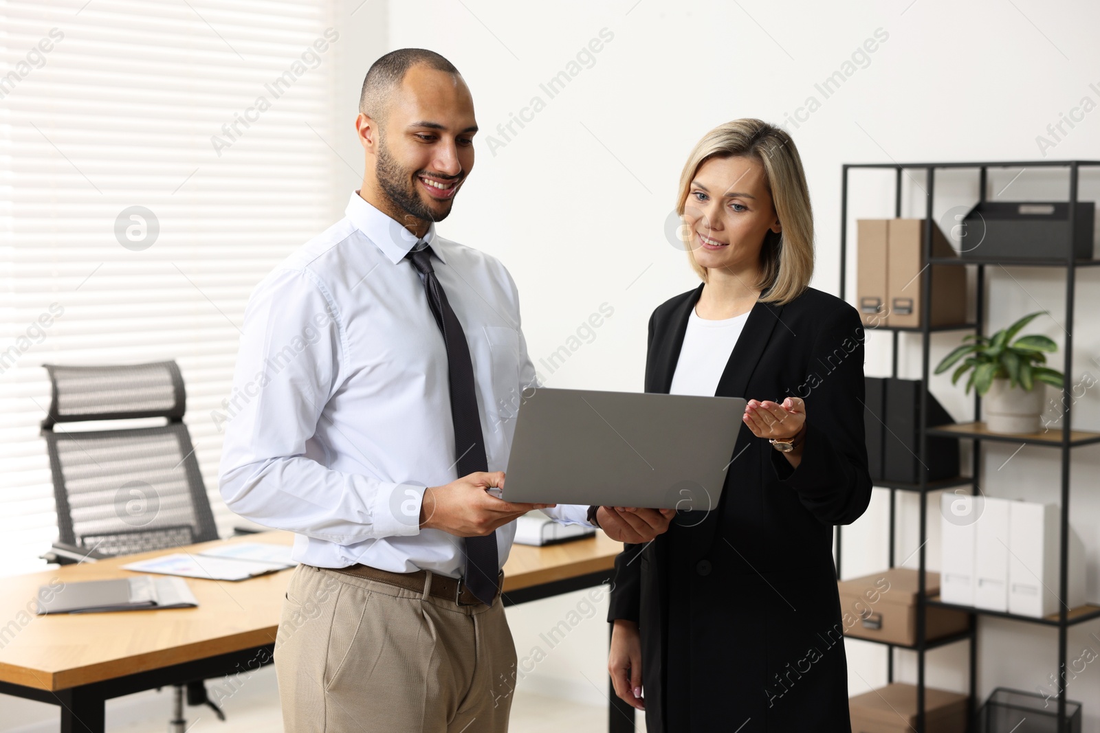 Photo of Coworkers with laptop working together in office