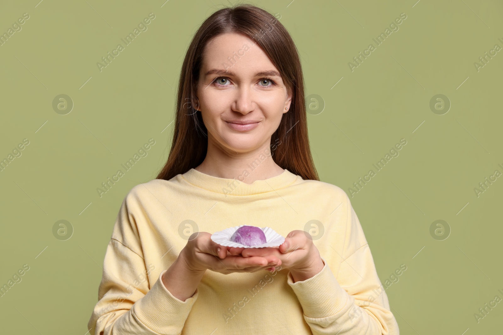 Photo of Woman with tasty mochi on olive background