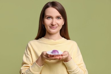 Photo of Woman with tasty mochi on olive background