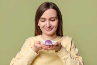 Photo of Woman with tasty mochi on olive background