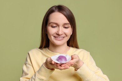 Photo of Woman with tasty mochi on olive background