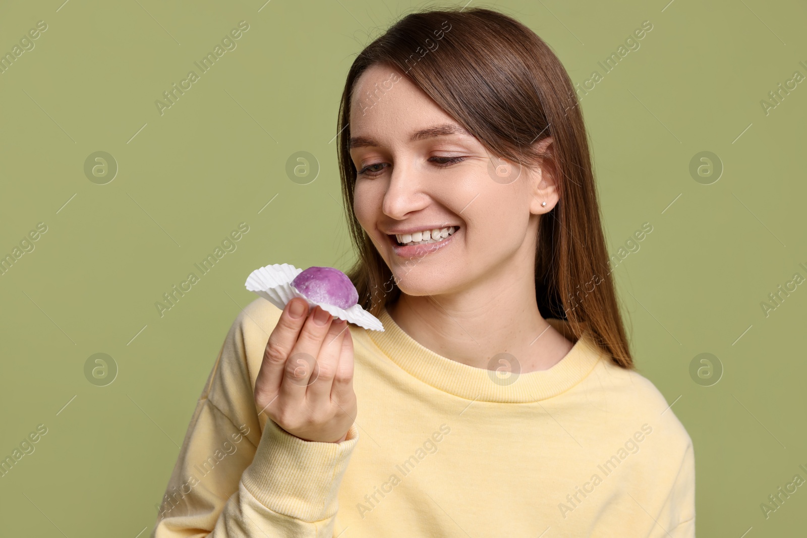 Photo of Woman with tasty mochi on olive background