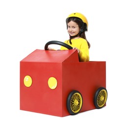 Photo of Little girl driving car made with cardboard on white background