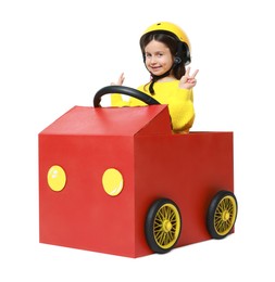 Photo of Little girl showing V-sign while driving car made with cardboard on white background