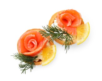 Photo of Tasty tartlets with salmon, lemon and dill isolated on white, top view