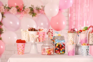 Photo of Candy bar. Many different sweets on table in festive decorated room