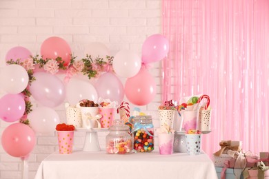 Photo of Candy bar. Many different sweets on table in festive decorated room