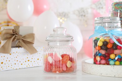 Photo of Candy bar. Many different sweets and gift boxes on white wooden table in festive decorated room