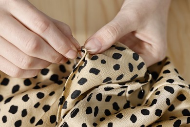 Photo of Woman sewing fabric with needle at table, top view