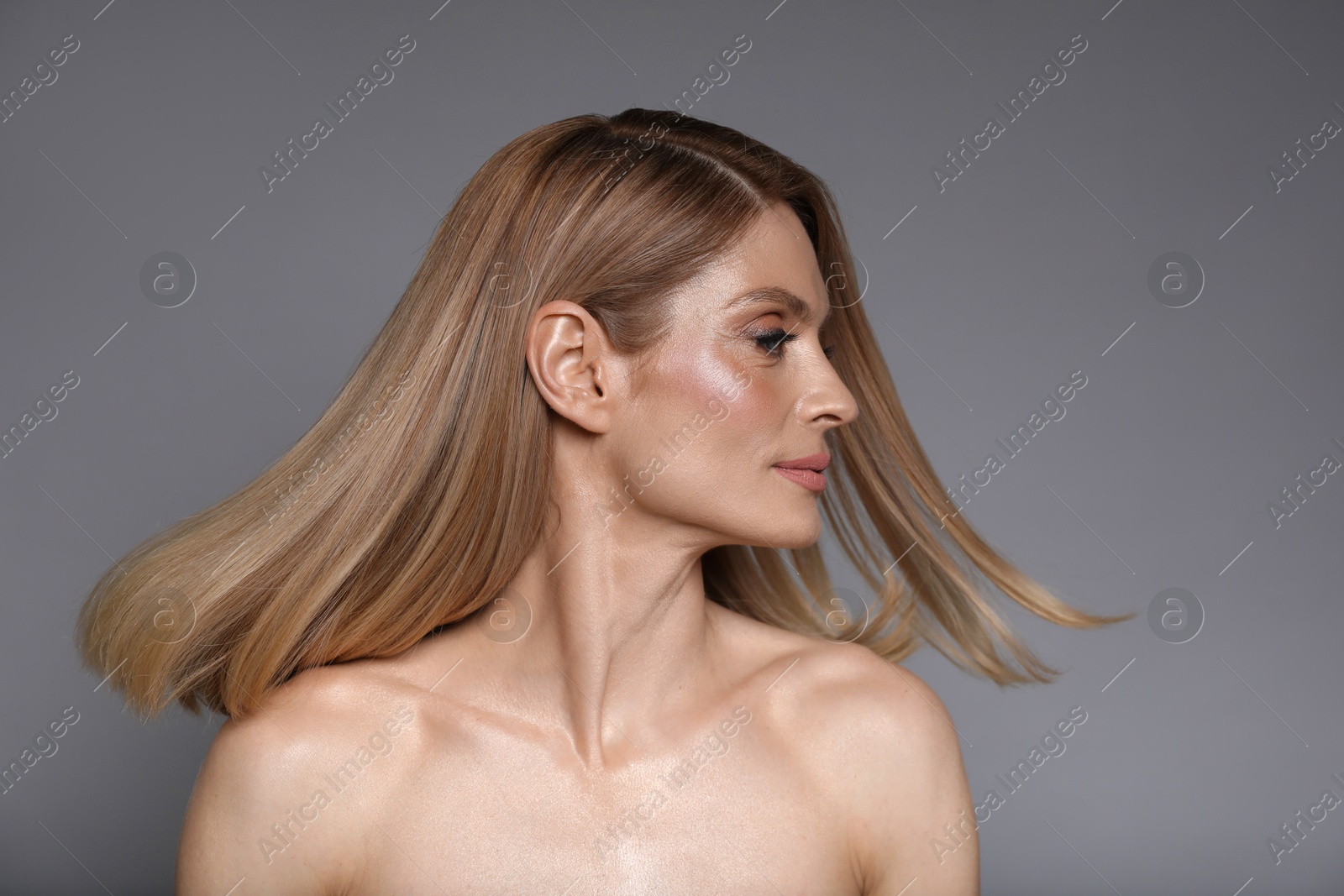 Photo of Portrait of beautiful woman with straight blonde hair on grey background