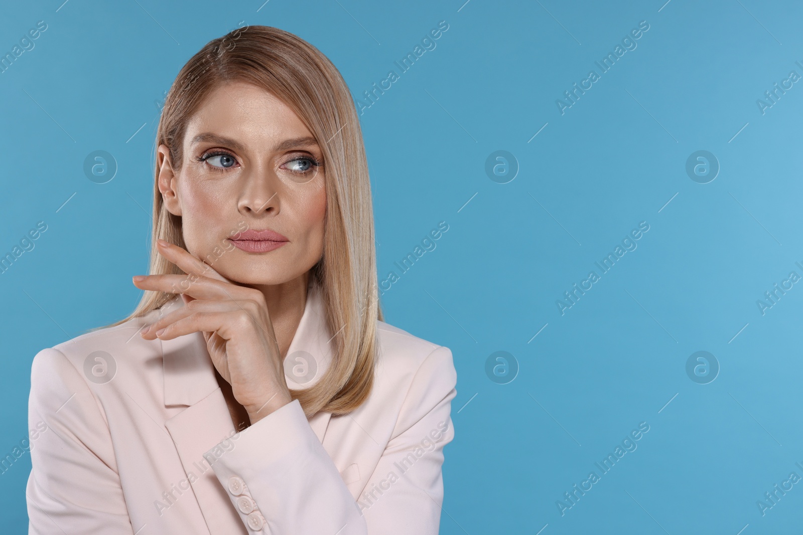 Photo of Portrait of beautiful woman with straight blonde hair on light blue background, space for text