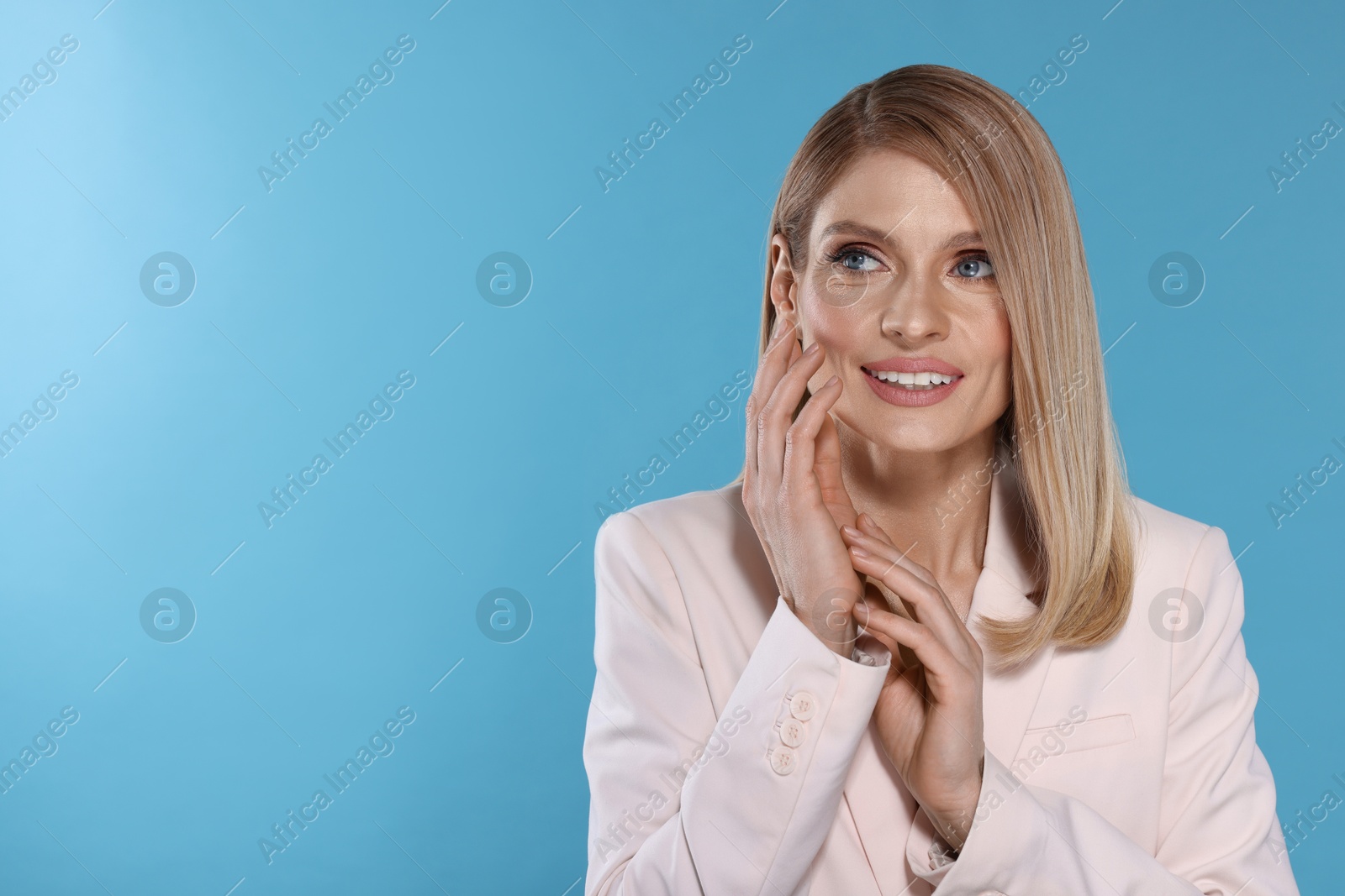 Photo of Beautiful happy woman with straight blonde hair on light blue background, space for text