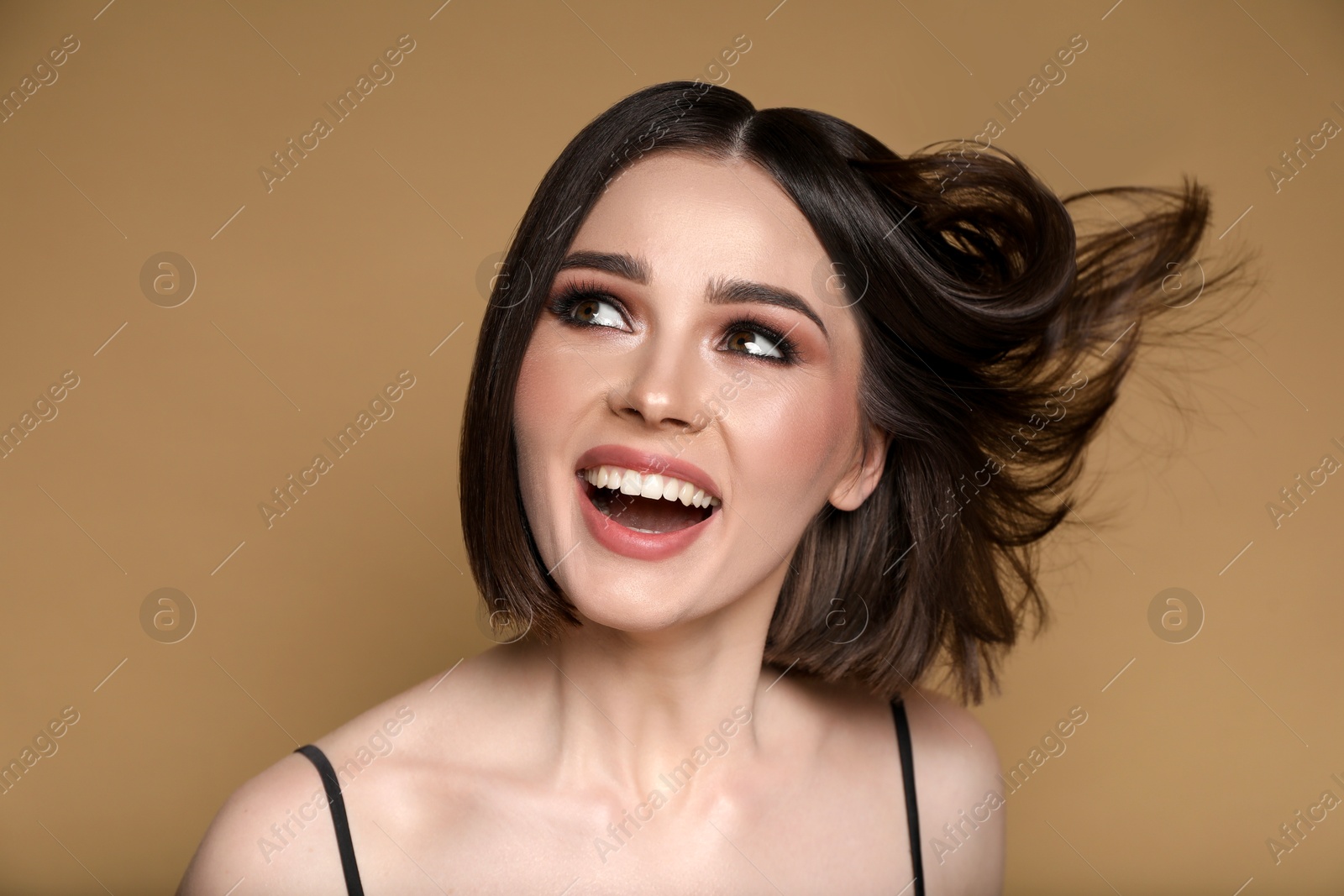 Photo of Portrait of beautiful young happy woman with gorgeous straight hair on dark beige background