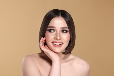 Photo of Portrait of beautiful young happy woman with gorgeous straight hair on beige background