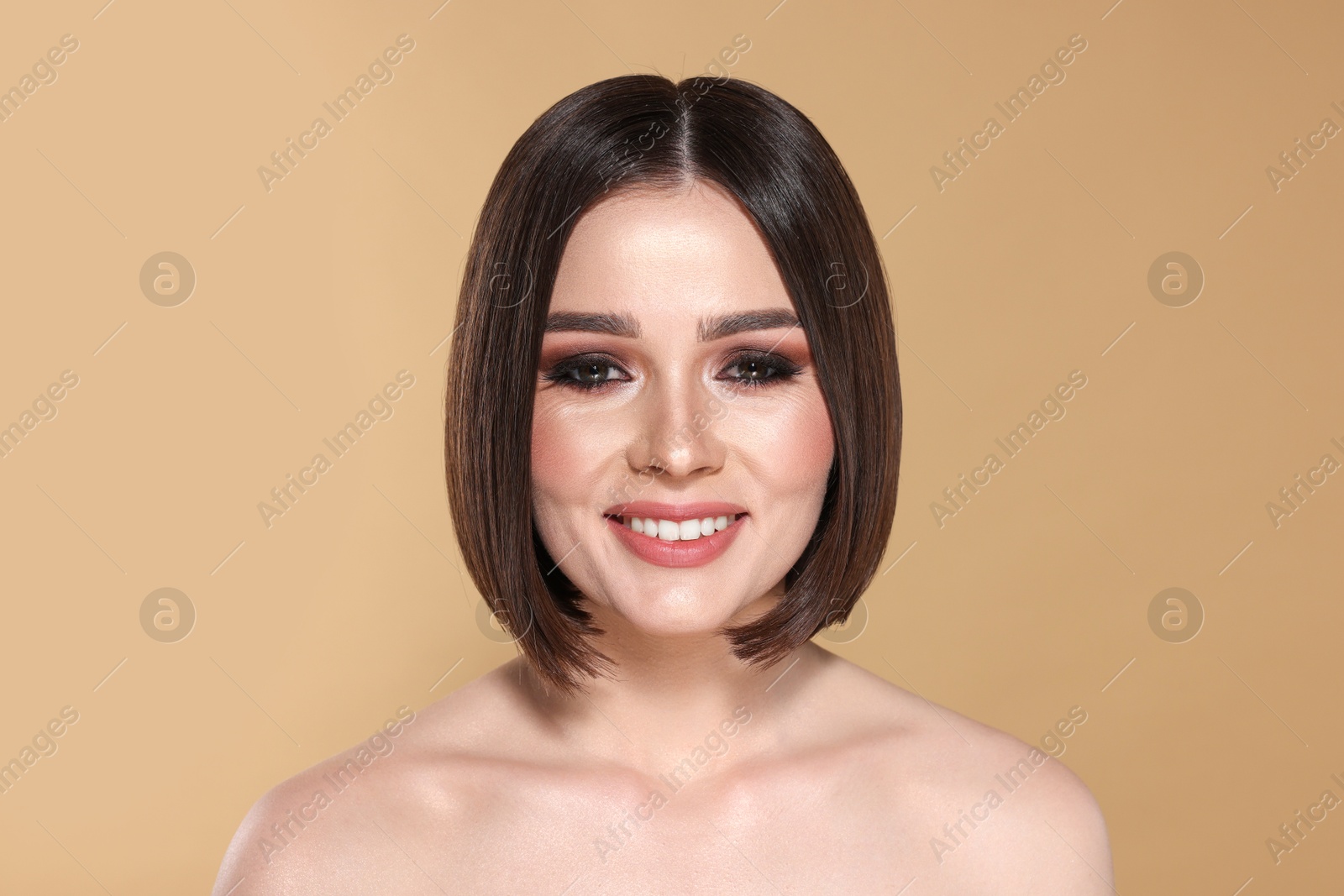 Photo of Portrait of beautiful young happy woman with gorgeous straight hair on beige background