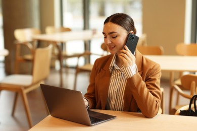 Photo of Woman in stylish formal suit working at table indoors