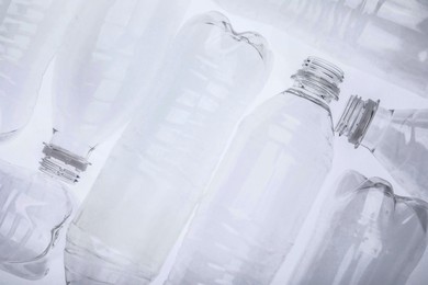 Photo of Empty plastic bottles on white background, top view