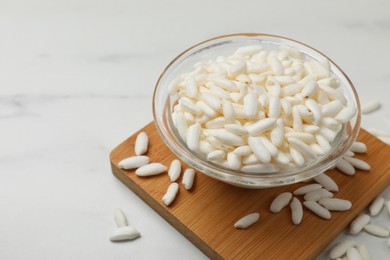 Photo of Puffed rice in bowl on white table, closeup