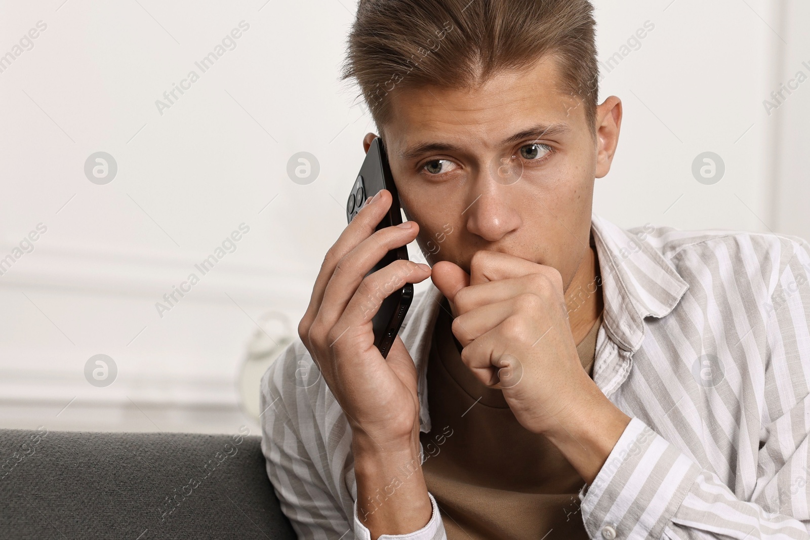 Photo of Worried man calling hotline for mental health help at home. Space for text