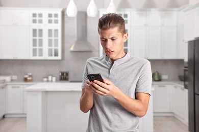 Photo of Worried man calling hotline for mental health help in kitchen. Space for text