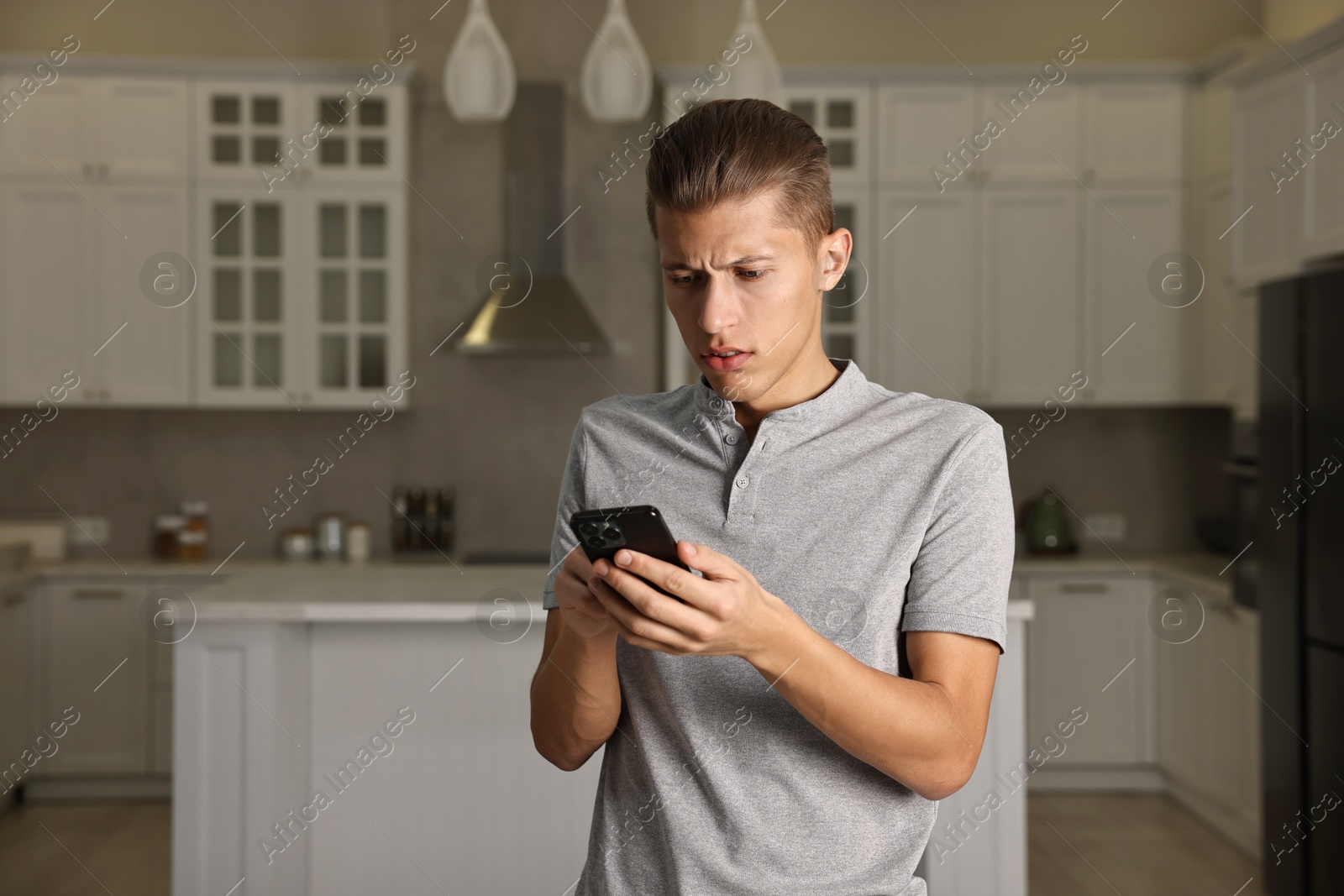 Photo of Worried man calling hotline for mental health help in kitchen. Space for text