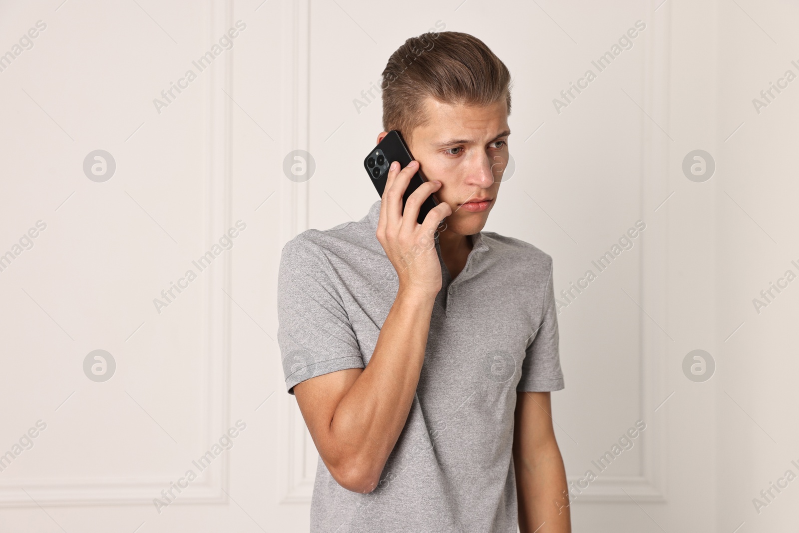 Photo of Frustrated man calling hotline for mental health help indoors. Space for text