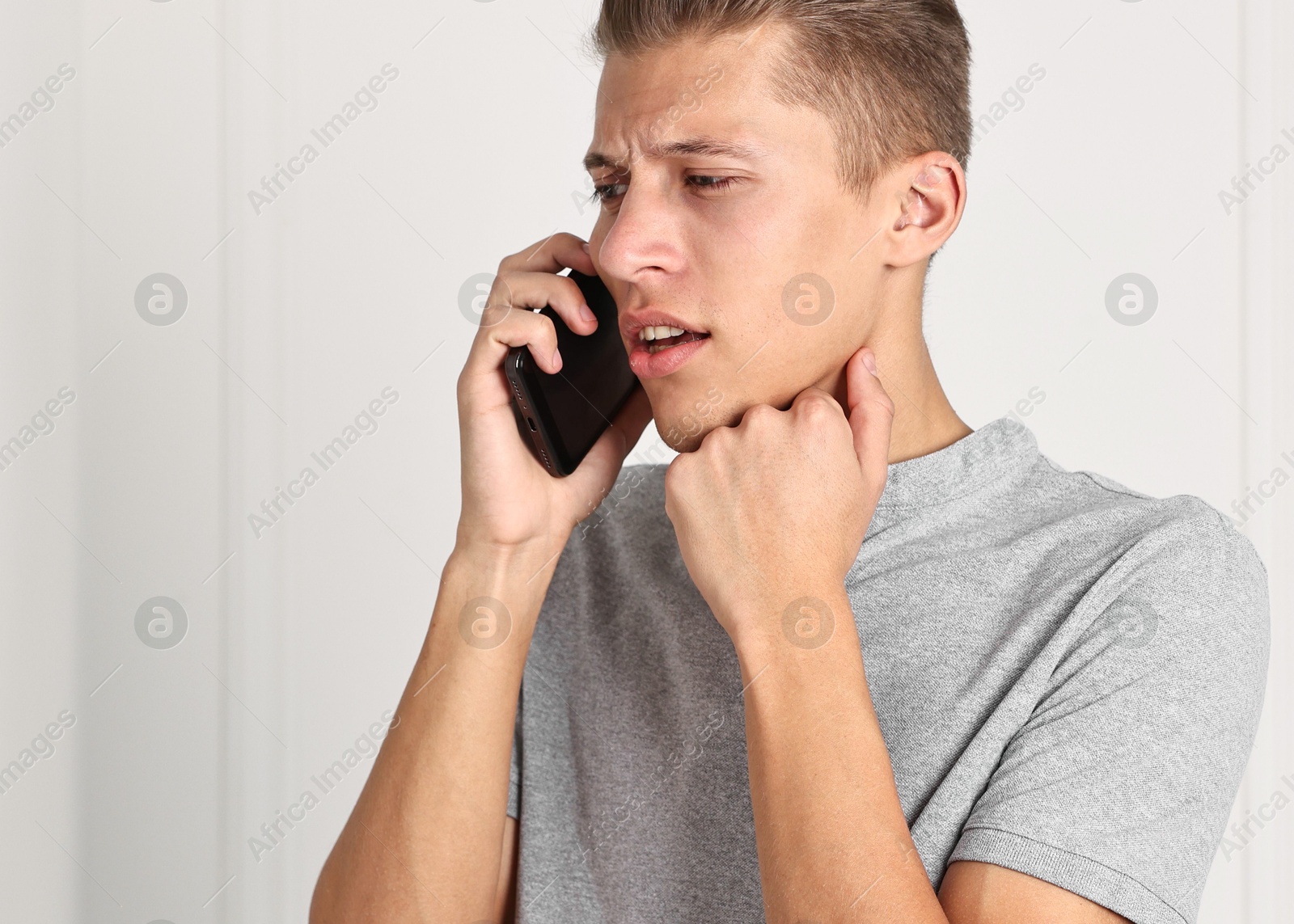 Photo of Worried man calling hotline for mental health help indoors. Space for text