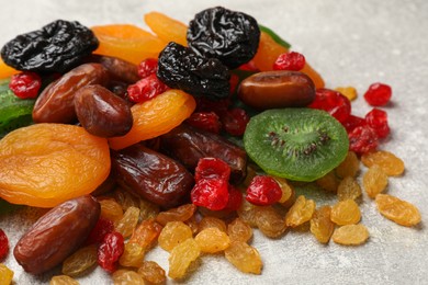 Photo of Mix of different dried fruits on light grey table, closeup