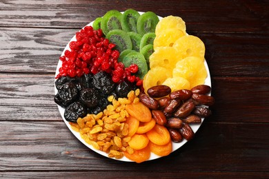 Photo of Mix of different dried fruits on wooden table, top view