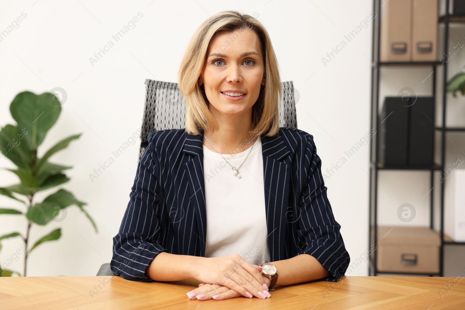 Photo of Portrait of happy businesswoman at table in office