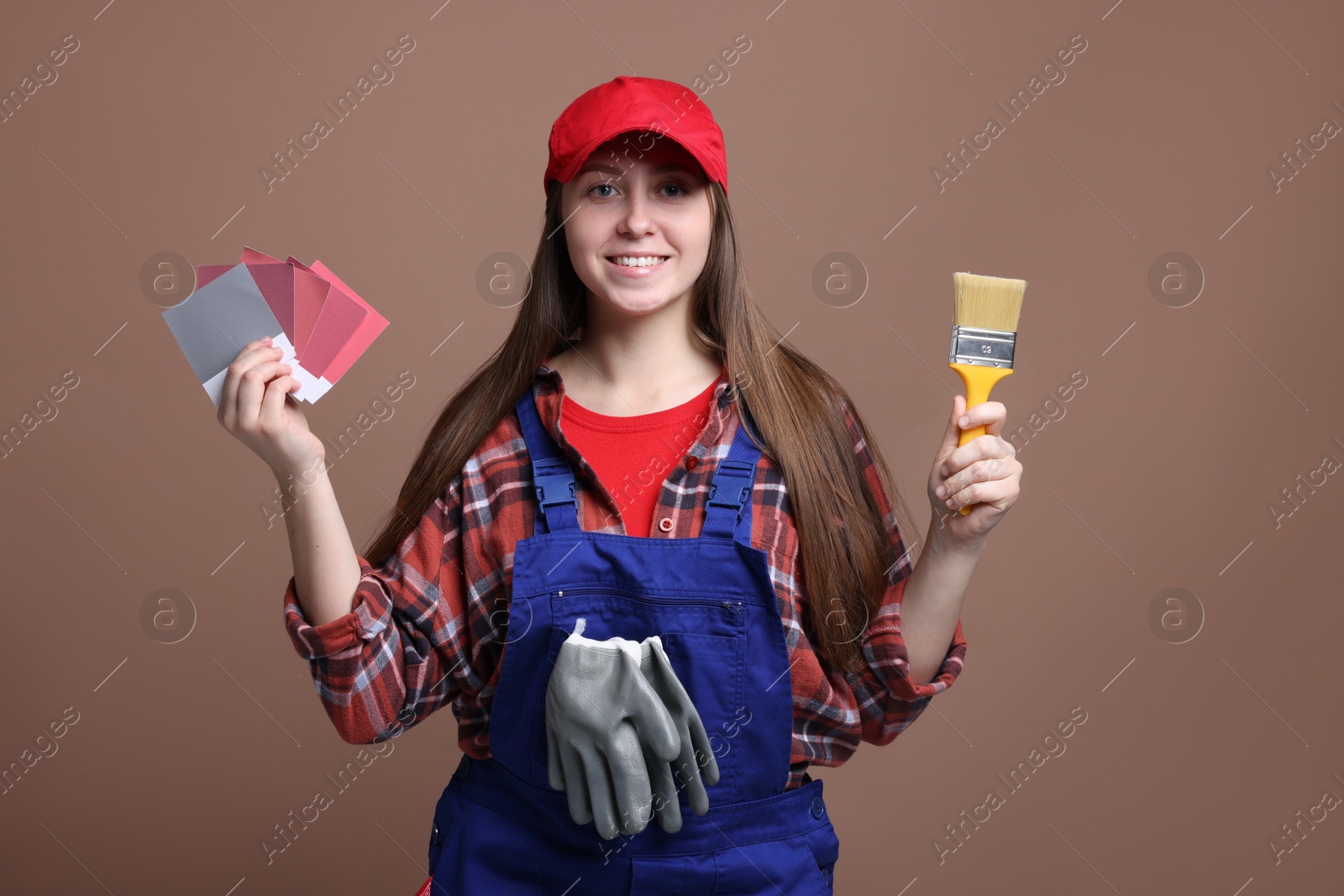 Photo of Professional painter with brush and color samples on brown background