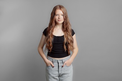 Photo of Teenage girl with healthy long hair on light grey background